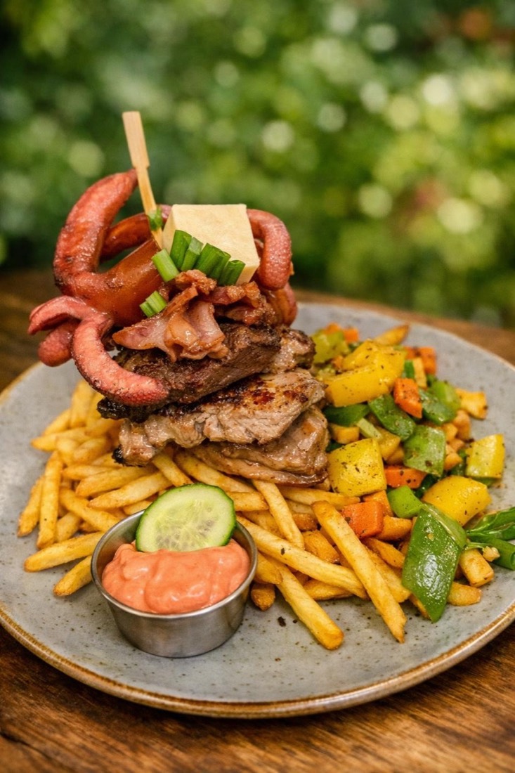 Burger mit Speck, Zwiebelringen, Pommes und Grillgemüse