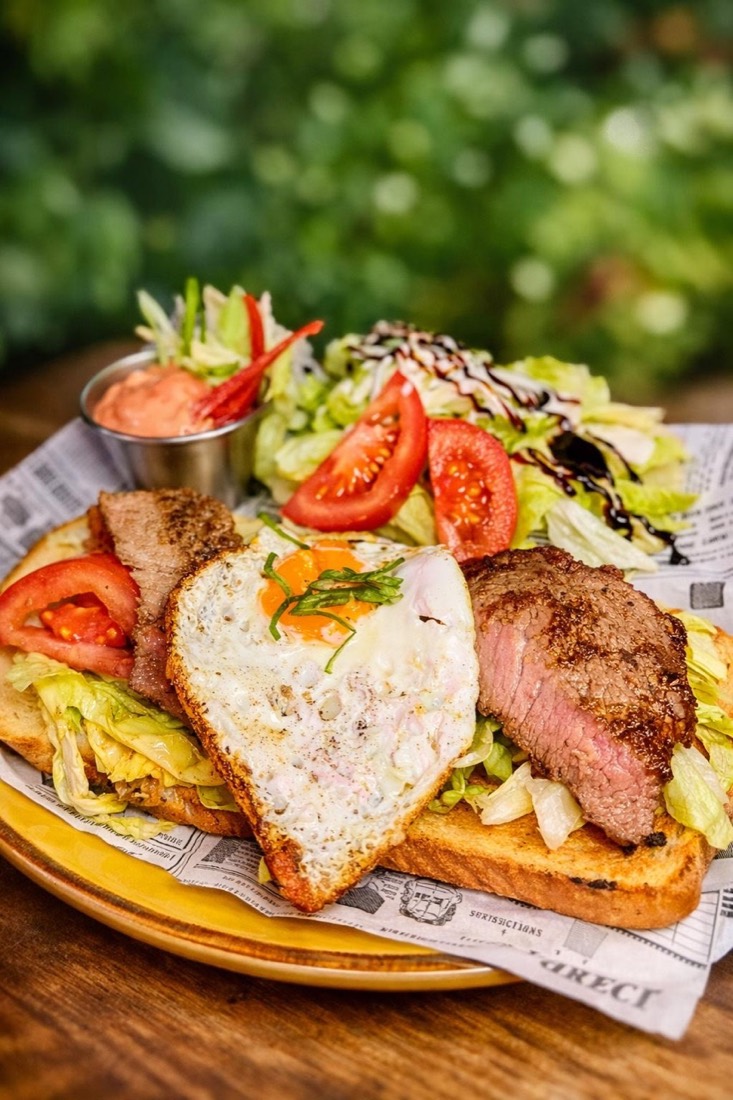 Steak auf Toast mit Spiegelei und Salat